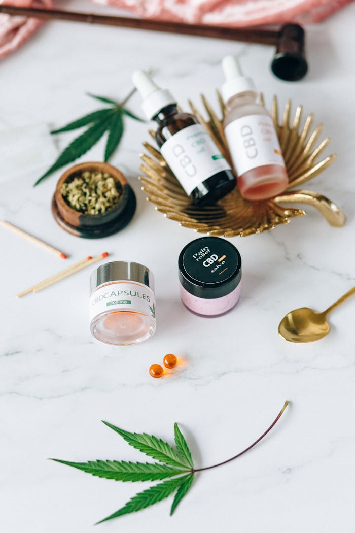 Home 5 Flat lay of CBD products including oils and capsules next to hemp leaves.